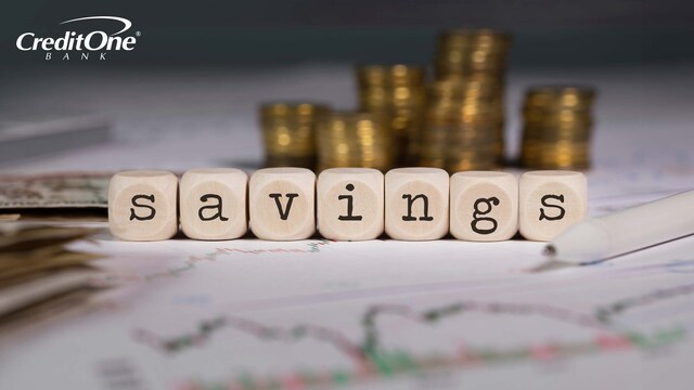 A series of blocks spells out “savings” in front of stacks of coins and bills, representing high-yield savings accounts.